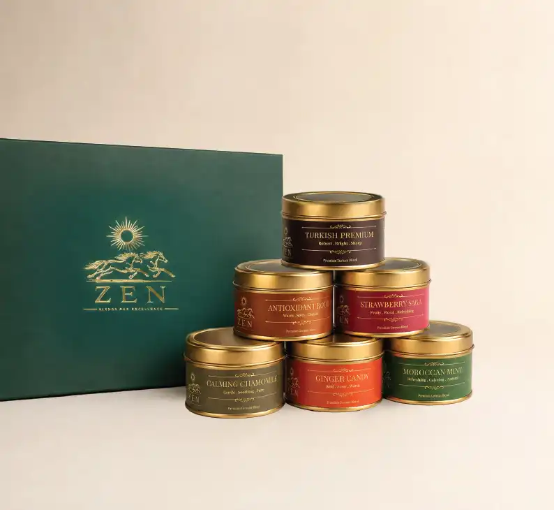 A high-end bespoke corporate gift set by ZEN, presented in a luxury deep forest green presentation box on a dark textured slate background. The open lid reveals gold foil branding and custom narrative text on the inside cover. Inside the box, six gold tins with clear viewing lids showcase a meticulously curated selection of vibrant, loose-leaf tea blends. To the left rests an elegant, minimalist matte gold spoon. In the foreground, a personalized cream-colored corporate card features a gold metallic logo and a custom appreciation message addressed to an individual, demonstrating ZEN’s tailored gifting services for businesses.